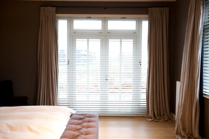 Slaapkamer met linnen gordijnen naturel en shutters